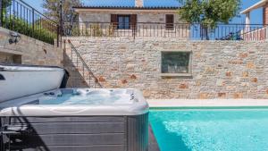 a bath tub sitting next to a swimming pool at Villa Zebo by Villas Guide in Barban +4 photos