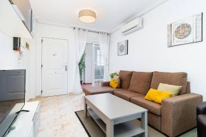 a living room with a couch and a table at Playa del Pinet Apartment in La Marina