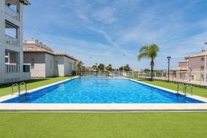 a large swimming pool in the middle of a yard at Playa del Pinet Apartment in La Marina