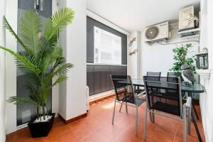 a dining room with a table and chairs and a plant at Playa del Pinet Apartment in La Marina