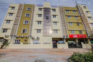 a tall building with a red sign on it at MVTJ Hotel in Bangalore