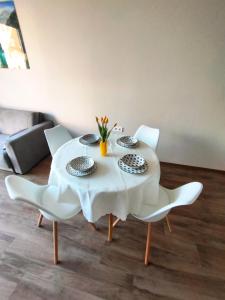 a dining room table with white chairs and a white table cloth at Apartment in Chantrer Residence with garage in Burgas