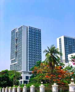two tall buildings in a city with a palm tree at Landmark Vientiane Life Center in Vientiane
