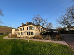 a large white house with a driveway at Saarwein Gut in Wiltingen in Wiltingen