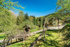 a wooden fence in a field with a house at Spinnertonihof in Bad Peterstal