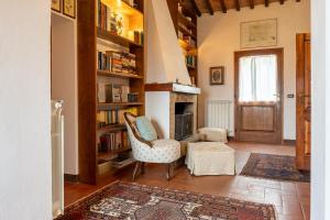 a living room with a chair and a fireplace at Capanne di Sopra in Torrita di Siena