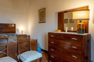 a bedroom with a dresser and a bed with a mirror at Capanne di Sopra in Torrita di Siena +81 photos