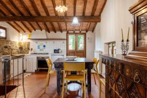 a kitchen with a wooden table and yellow chairs at Capanne di Sopra in Torrita di Siena