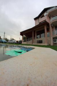 a house with a pool of water in front of it at Hotel Akre in Kavarna