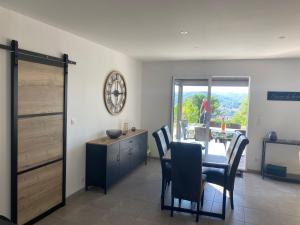 a dining room with a table and chairs and a window at Vacances Vallée de la Dordogne in Souillac