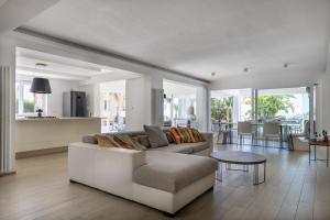 a living room with a white couch and a table at Villa Annalisa by PosarelliVillas in Pizzolungo