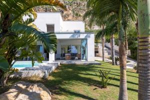 a villa with a pool and palm trees at Villa Annalisa by PosarelliVillas in Pizzolungo
