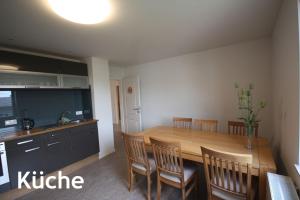 a kitchen and dining room with a wooden table and chairs at Pension Luci in Boffzen