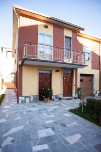 バニョレージョにあるCasa Vacanze Evelinaのレンガ造りの家で、バルコニーとパティオが付いています。