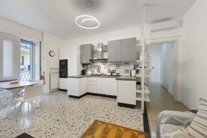 a kitchen with white cabinets and a table in a room at Beautifulliguria in Sestri Levante