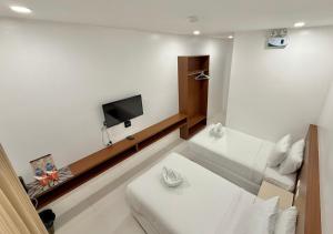 a room with two beds and a flat screen tv at Cris Inn Samal in Samal