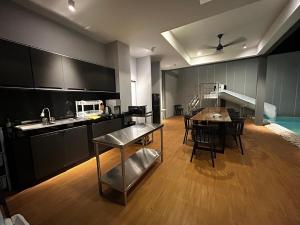 a large kitchen with a table and chairs in it at บลูด้าพูลวิลล่าซี Bludapoolvilla C in Ban Khlong Toei (1)
