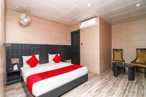 a bedroom with a bed with red pillows and a desk at FabHotel Ace Prime in Greater Noida