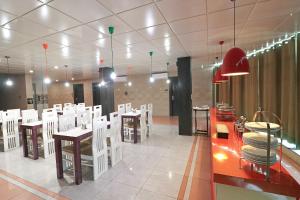 a restaurant with white chairs and tables in a room at FabHotel Ace Prime in Greater Noida