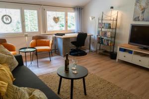 a living room with a couch and a table with a tv at Ferienwohnung Belchenzeit in Münstertal