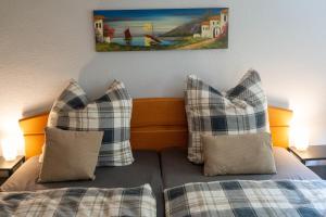 a bed with two pillows and a picture on the wall at Ferienwohnung Belchenzeit in Münstertal