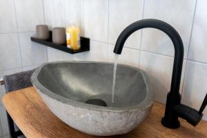 a sink with water coming out of it at Ferienwohnung Belchenzeit in Münstertal +29 photos