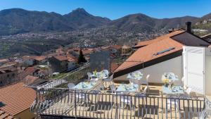 a balcony with tables and chairs with mountains in the background at L'Incanto dei Monti in Agerola