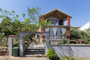 a house with a gate in front of it at House on the sea in Preko