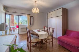 a living room with a table and a red couch at House on the sea in Preko