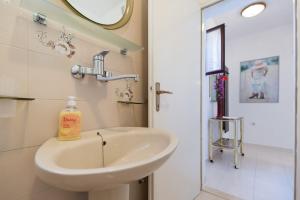 a bathroom with a sink and a mirror at House on the sea in Preko +12 photos
