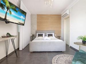 a bedroom with a bed and a flat screen tv at כינור דוד המלך במנות in Manot