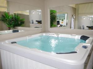 a large bath tub with blue water in a bathroom at כינור דוד המלך במנות in Manot