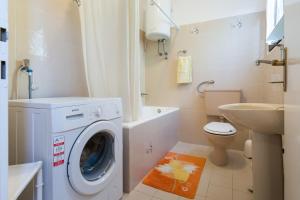 a bathroom with a washing machine and a sink at House on the sea in Preko