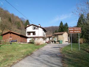 un cartello stradale di fronte a una casa bianca di B&B IN FATTORIA a Frisanco