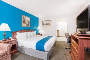 a hotel room with a bed and a flat screen tv at Baymont by Wyndham Duncan/Spartanburg in Duncan