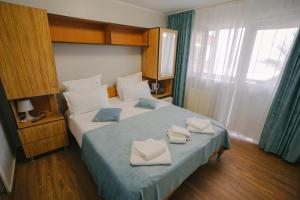 a bedroom with a bed with towels on it at Hotel Sunset Beach Vama Veche in Vama Veche