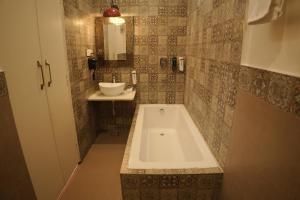a bathroom with a bath tub and a sink at Artistik Abode by Stay Banaras in Varanasi +68 photos