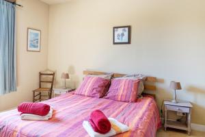 a bedroom with a bed with pink sheets and pillows at La Jouanhitte in Bourrouillan +22 photos