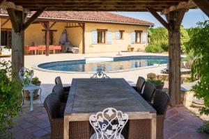 a patio with a table and chairs and a pool at La Jouanhitte in Bourrouillan