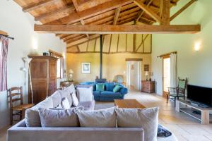 a living room with a couch and a tv at La Jouanhitte in Bourrouillan