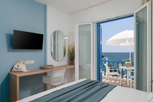 a bedroom with a bed and a view of the ocean at Apanemo Seaside in Batsi