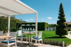 a patio with a table and chairs under a pavilion at Divina Costiera in Agerola