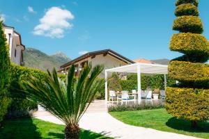 a garden with a pavilion and a palm tree at Divina Costiera in Agerola
