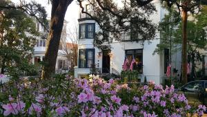 a white house with pink flowers in front of it at Ballastone Inn in Savannah