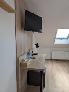a room with a desk with a television on a wall at Penzion Ema B&B in Prostějov