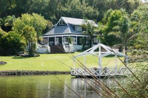 a house with a boat in front of it at MoonWillow Manor in Dairy Flat