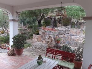 a red bench sitting in front of a stone wall at Bellavista Coghinas in Oschiri