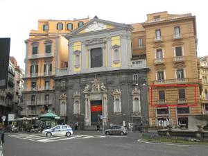 un viejo edificio con coches aparcados delante de él en B&B Dell'Opera, en Nápoles