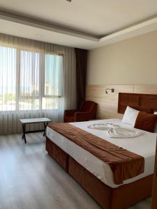 a hotel room with a large bed and a chair at Mitra Black Sea in Arhavi