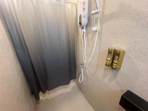 a shower in a room with a phone on the wall at Urban Capsule by Faradale in Kuching +34 photos